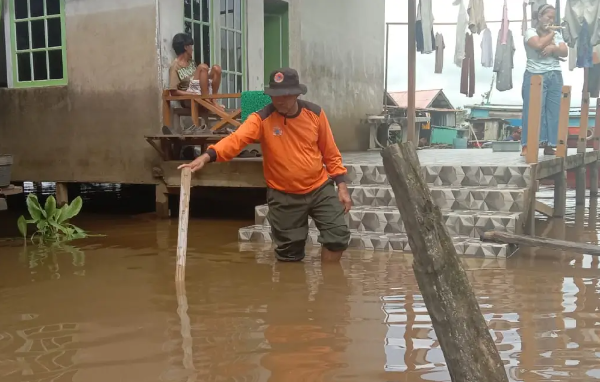 warga membersihkan lumpur pasca banjir di sintang